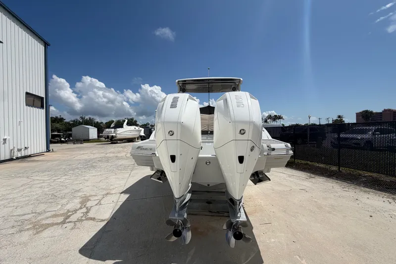 Slide: The Image of 2019 Crownline Eclipse E295 XS boat with dual outboard engines, parked outdoors. - 5