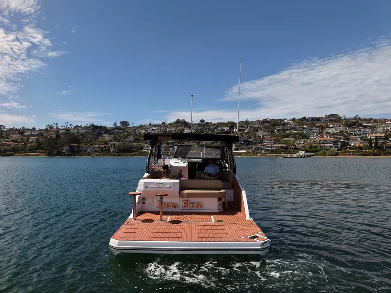 Slide: The Image of Rear view of a 2024 Hanover 387 yacht on calm water with a town in the background. - 4