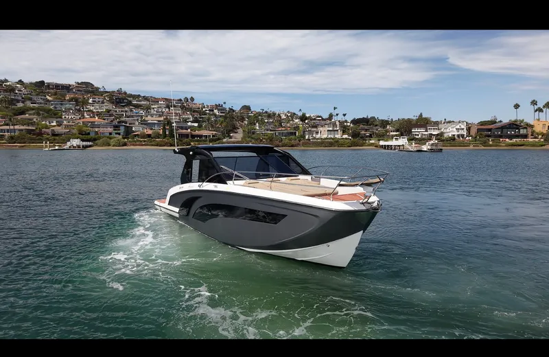 Slide: The Image of The image shows a modern boat on calm water with a coastal town in the background. - 19