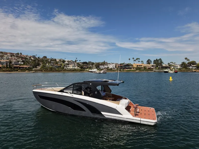 Slide: The Image of The image shows a modern motorboat on calm water with a coastal town in the background. - 1