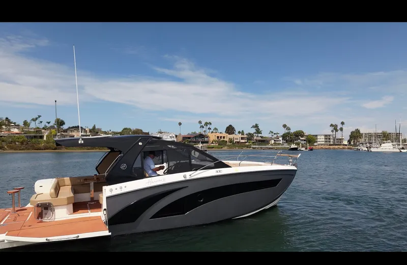 Slide: The Image of A modern boat with sleek design, on calm water near a coastal town. - 6
