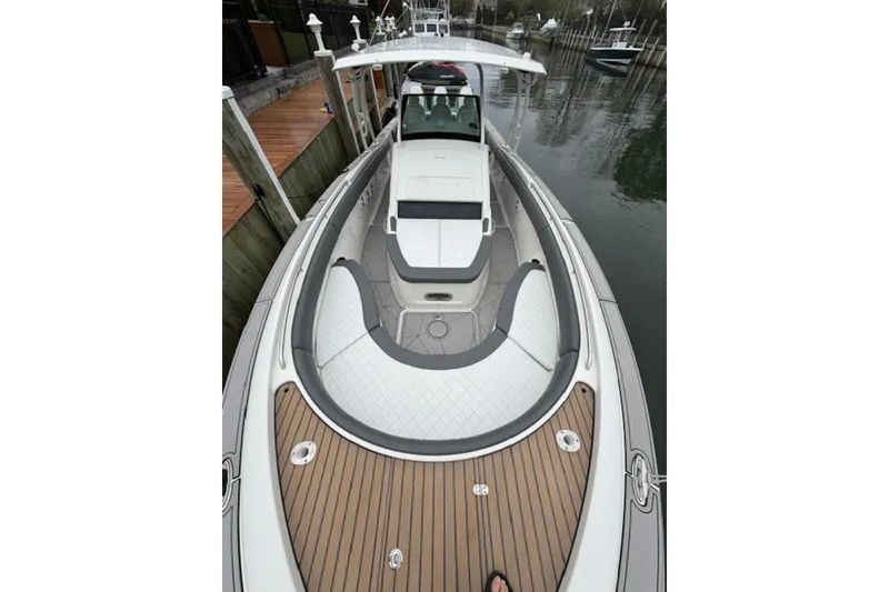 Slide: The Image of 2016 Chris-Craft Catalina 34 boat with elegant deck and seating, docked by the water. - 2