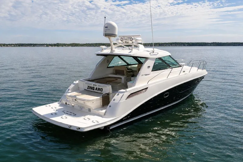 The Image of 2013 Sea Ray 450 Sundancer yacht on calm water under a partly cloudy sky. - 0