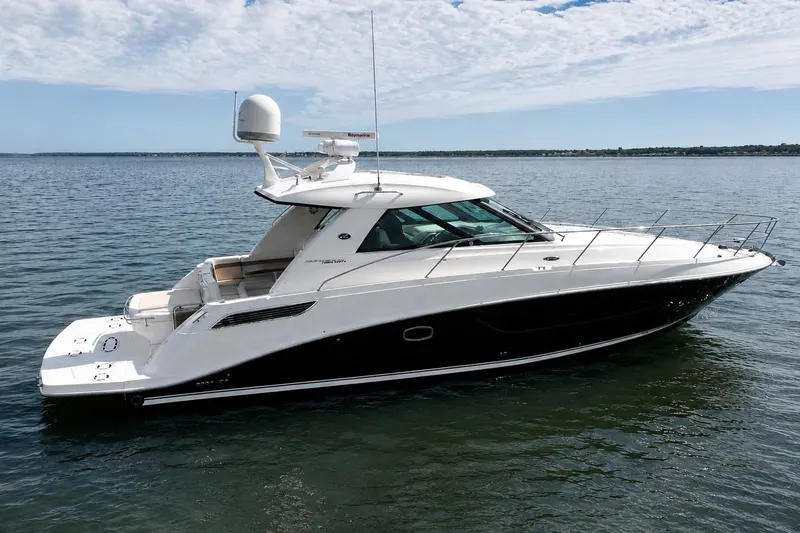 Slide: The Image of 2013 Sea Ray 450 Sundancer yacht cruising on calm waters under a partly cloudy sky. - 2