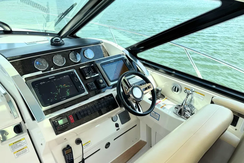 Slide: The Image of Helm of 2013 Sea Ray 450 Sundancer with advanced navigation systems and controls. - 23