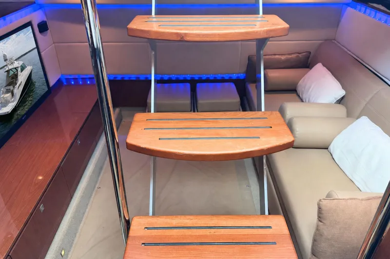 Slide: The Image of Interior of 2013 Sea Ray 450 Sundancer yacht with wooden steps and cozy seating area. - 29