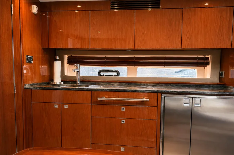 Slide: The Image of Luxurious 2013 Sea Ray 450 Sundancer yacht interior with sleek wooden cabinetry and modern appliances. - 36