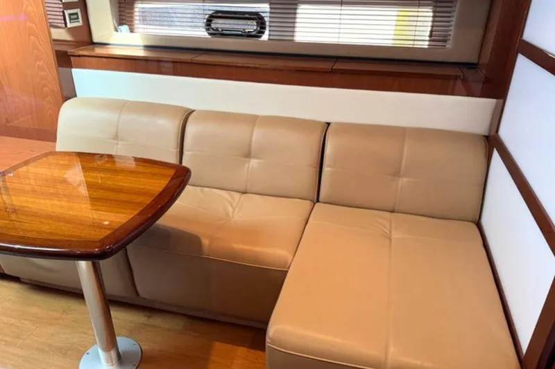 Slide: The Image of Luxurious interior of 2013 Sea Ray 450 Sundancer with beige leather seating and wooden table. - 39