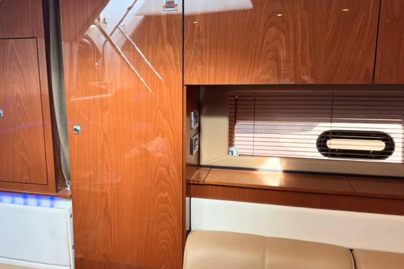 Slide: The Image of Interior of 2013 Sea Ray 450 Sundancer yacht with polished wood finish and window blinds. - 42