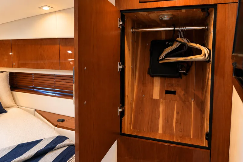 Slide: The Image of Luxurious 2013 Sea Ray 450 Sundancer cabin with open wooden wardrobe and cozy bedding. - 55