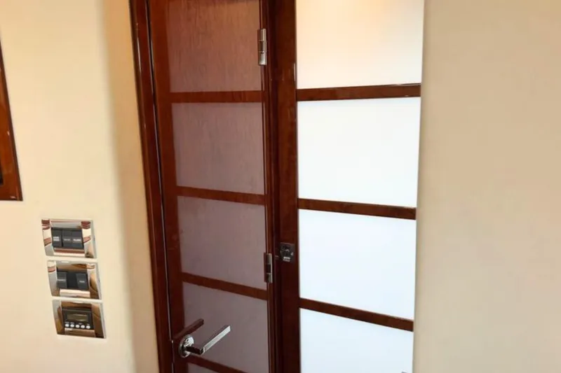 Slide: The Image of Interior door of 2013 Sea Ray 450 Sundancer yacht, featuring modern wood and frosted glass design. - 57