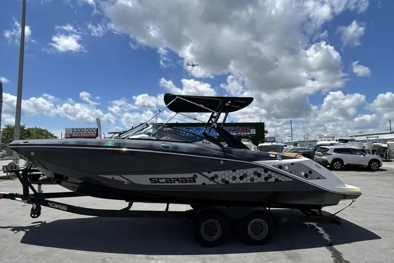 The Image of 2019 Scarab 255 ID boat on trailer under a partly cloudy sky. - 0