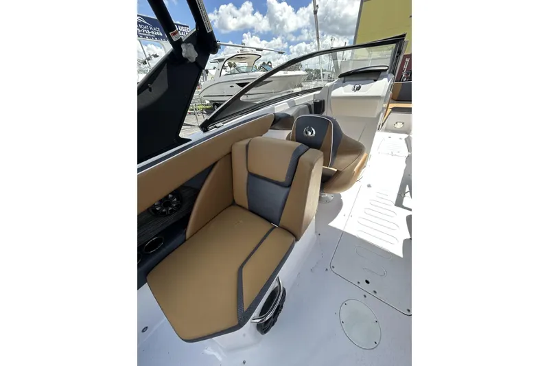 Slide: The Image of 2019 Scarab 255 ID boat interior with tan and gray seating under a sunny sky. - 10