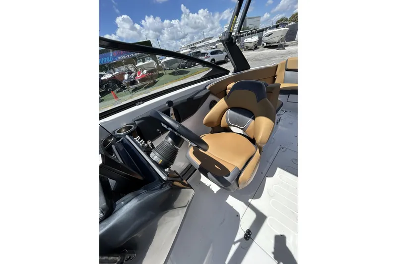 Slide: The Image of 2019 Scarab 255 ID boat interior with tan and black seating, steering wheel, and dashboard. - 14