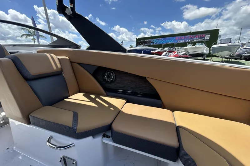 Slide: The Image of Interior of 2019 Scarab 255 ID boat with tan and black seating, outdoor setting. - 17