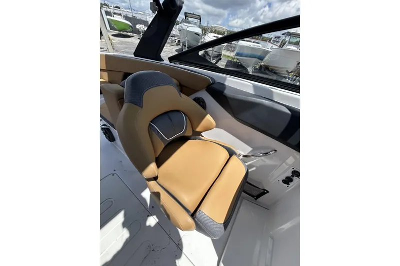 Slide: The Image of Captain's seat in 2019 Scarab 255 ID boat, featuring tan and gray upholstery. - 19