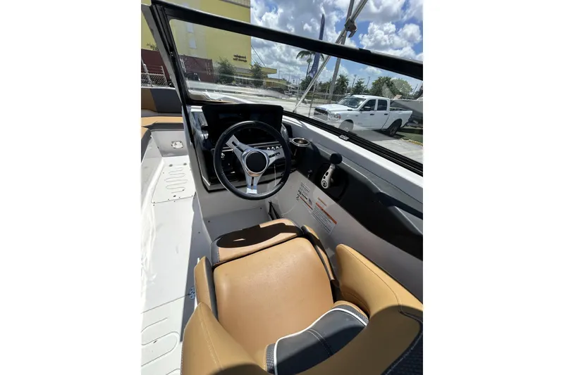 Slide: The Image of Interior view of 2019 Scarab 255 ID boat cockpit with steering wheel and tan seating. - 23
