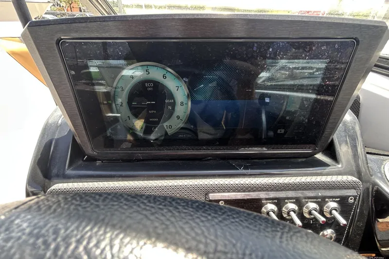 Slide: The Image of Dashboard of a 2019 Scarab 255 ID boat with digital display and control switches. - 25