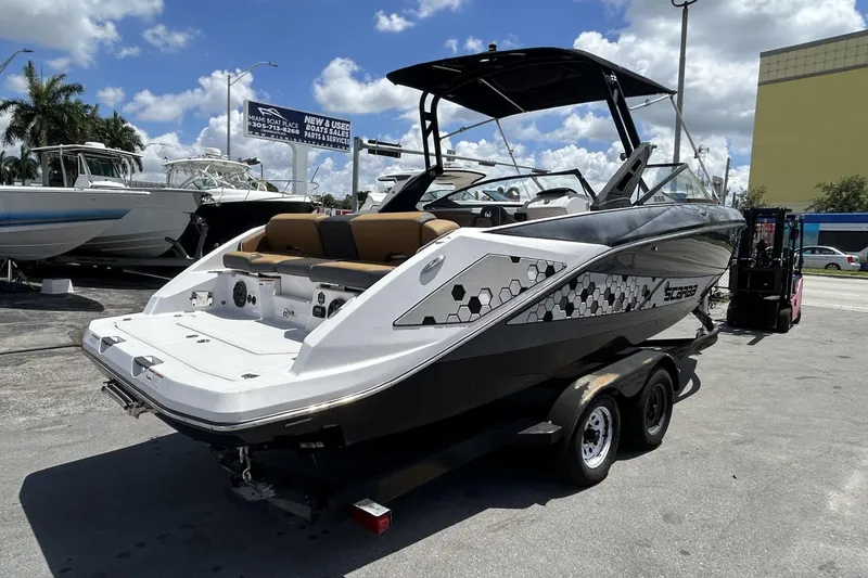 Slide: The Image of 2019 Scarab 255 ID boat on trailer, displayed outdoors under a sunny sky. - 3