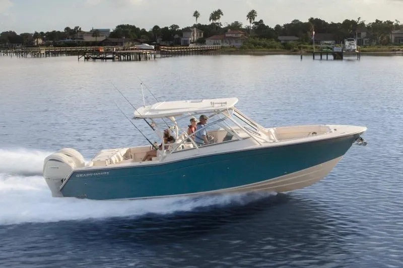 The Image of 2027 Grady-White Freedom 307 boat cruising on calm waters near a scenic shoreline. - 0