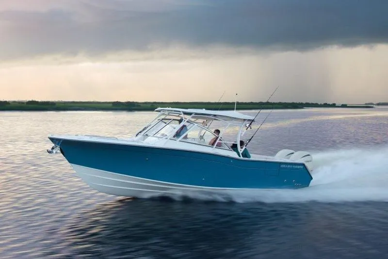 Slide: The Image of 2027 Grady-White Freedom 307 boat cruising on calm water at sunset. - 1