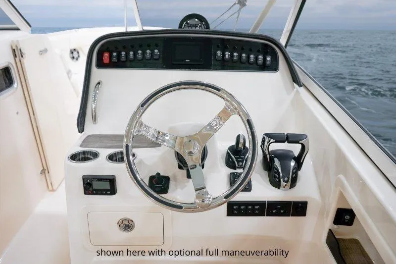 Slide: The Image of 2027 Grady-White Freedom 307 boat helm with advanced controls and ocean view. - 11