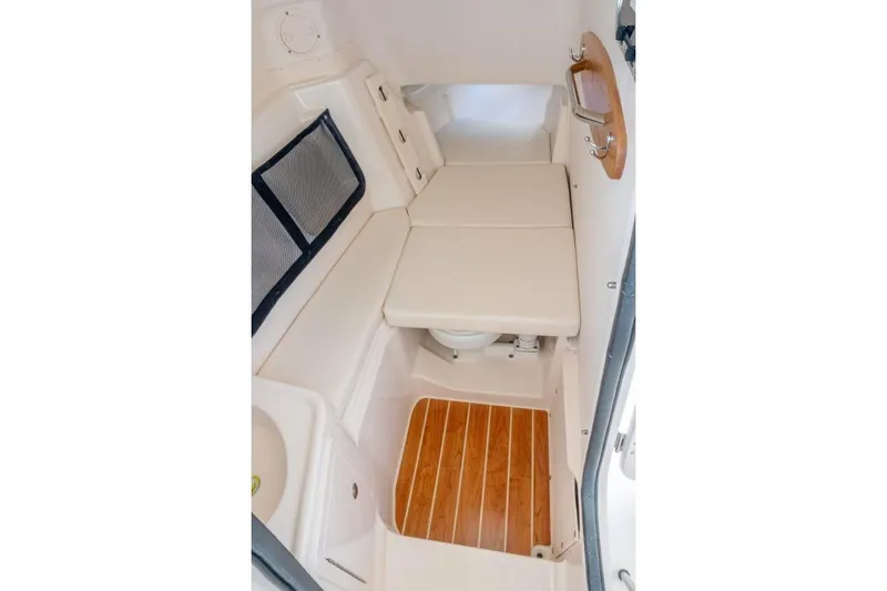 Slide: The Image of 2027 Grady-White Freedom 307 cabin interior with cushioned seating and wooden flooring. - 12