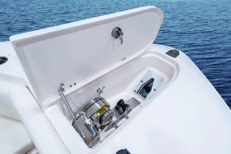 Slide: The Image of 2027 Grady-White Freedom 307 boat anchor compartment open on calm blue water. - 15