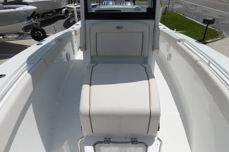 Slide: The Image of 2022 Sea Hunt Gamefish 27 Coffin Box boat interior with white seating and storage. - 25