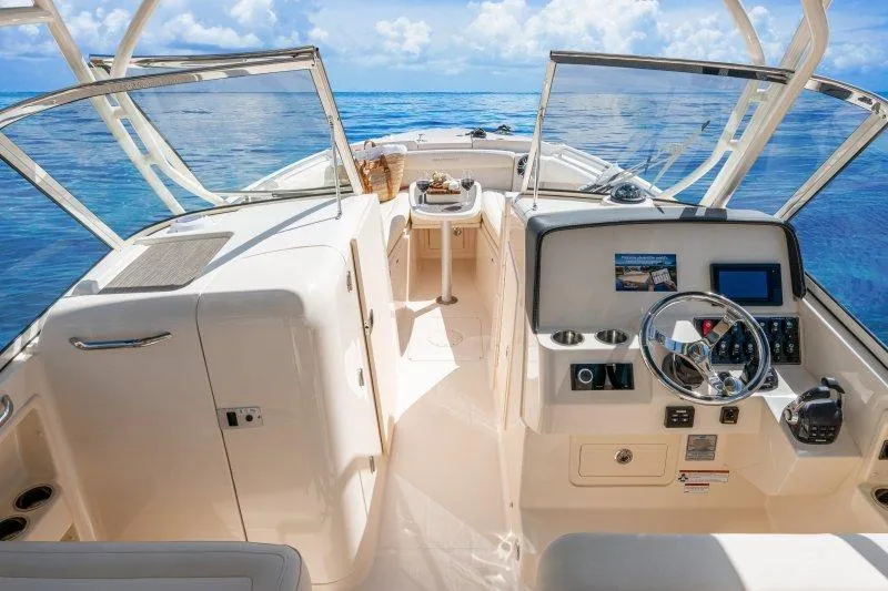 Slide: The Image of 2027 Grady-White Freedom 285 boat interior with ocean view, featuring modern controls and seating. - 7