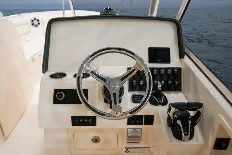 Slide: The Image of 2027 Grady-White Freedom 285 boat helm with steering wheel and control panel. - 8