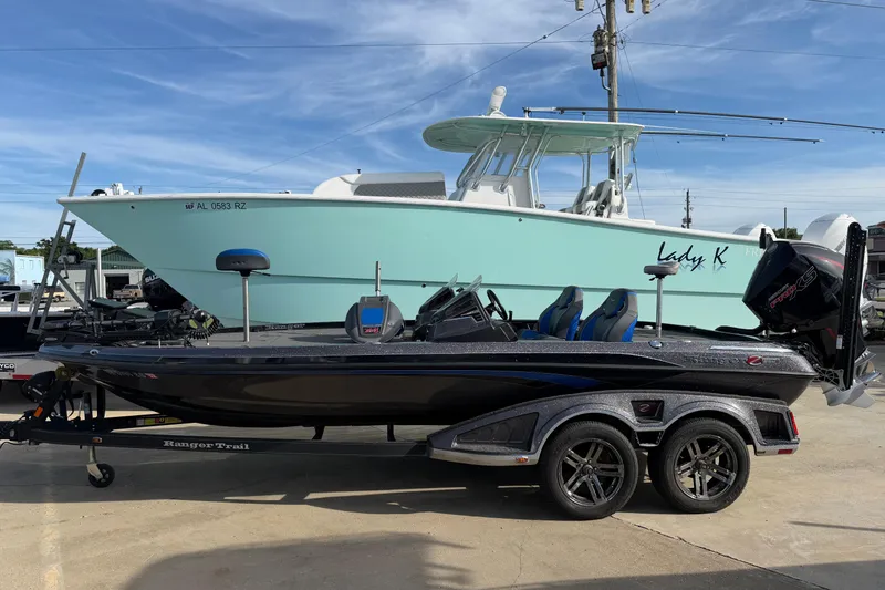 The Image of 2022 Ranger Z520R Cup-Equipped boat on trailer, parked beside a larger vessel. - 0