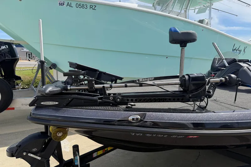 Slide: The Image of 2022 Ranger Z520R Cup-Equipped boat with Power-Pole, docked beside a larger vessel. - 105