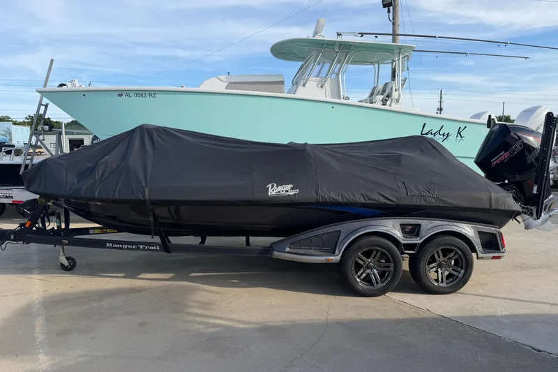 Slide: The Image of 2022 Ranger Z520R Cup-Equipped boat covered on trailer, parked beside a larger boat. - 115