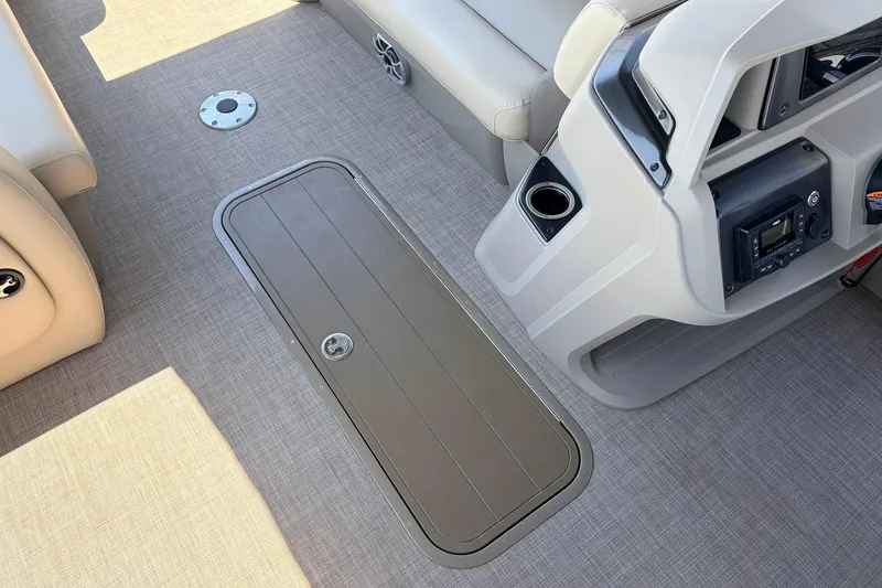Slide: The Image of 2024 Sun Tracker SportFish 22 XP3 boat interior with storage hatch and control panel. - 22