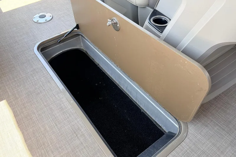 Slide: The Image of Open storage compartment on 2024 Sun Tracker SportFish 22 XP3 boat, featuring beige interior. - 23