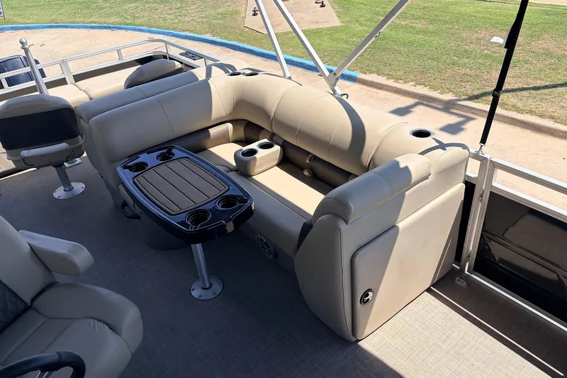 Slide: The Image of 2024 Sun Tracker SportFish 22 XP3 pontoon boat with beige seating and table. - 24
