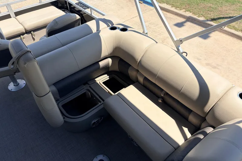 Slide: The Image of 2024 Sun Tracker SportFish 22 XP3 pontoon boat interior with beige seating and storage compartments. - 30