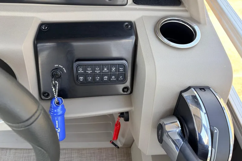 Slide: The Image of 2024 Sun Tracker SportFish 22 XP3 dashboard with ignition, controls, and cup holder. - 38