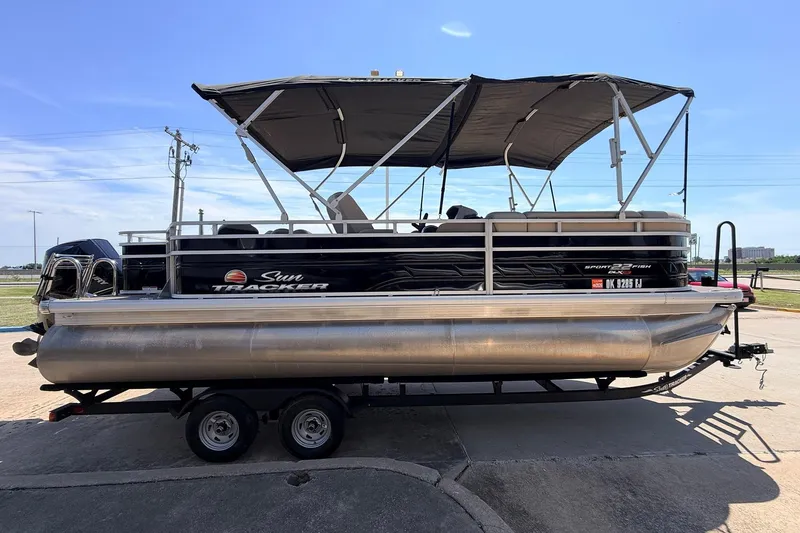 Slide: The Image of 2024 Sun Tracker SportFish 22 XP3 pontoon boat on trailer, side view. - 4