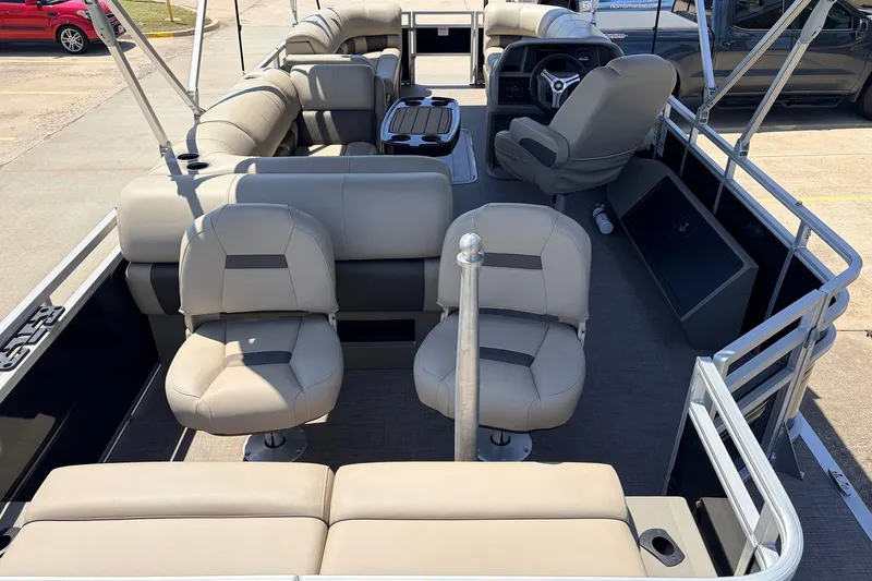 Slide: The Image of 2024 Sun Tracker SportFish 22 XP3 pontoon boat interior with beige seating and steering console. - 9