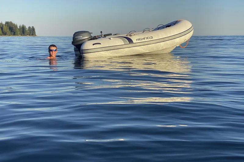 Slide: The Image of Man swimming near 2026 Highfield UltraLite 290 inflatable boat on calm water. - 3