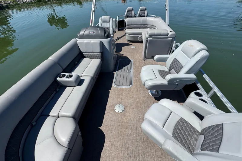 Slide: The Image of 2022 Ranger 223FC pontoon boat with luxurious seating on calm water. - 13