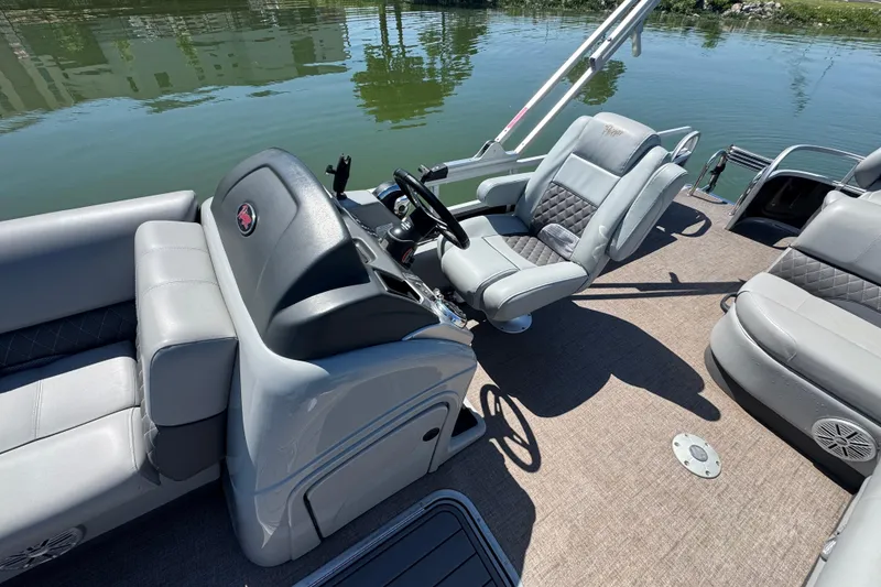 Slide: The Image of 2022 Ranger 223FC boat interior with plush seating and steering wheel on calm water. - 14
