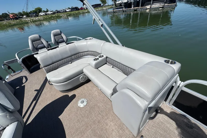 Slide: The Image of 2022 Ranger 223FC boat with spacious seating, cup holders, and scenic lake view. - 19