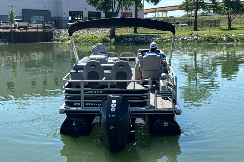 Slide: The Image of 2022 Ranger 223FC pontoon boat on a calm lake, featuring a powerful 200 V6 engine. - 5