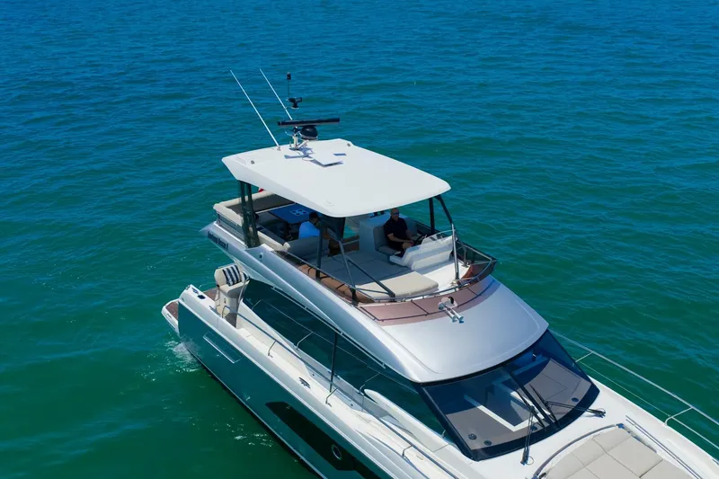 Slide: The Image of Luxury 2022 Prestige 520 yacht cruising on clear blue ocean waters. - 111