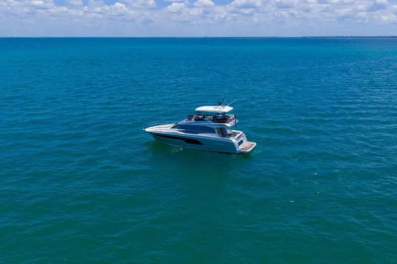 Slide: The Image of Luxury 2022 Prestige 520 yacht cruising on clear blue ocean waters. - 116