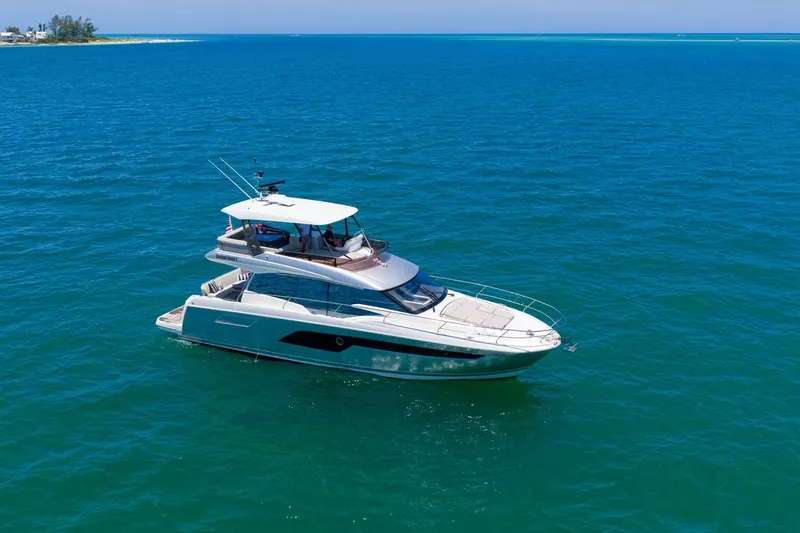 Slide: The Image of Luxury 2022 Prestige 520 yacht cruising on clear blue ocean waters. - 117