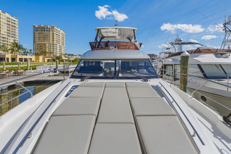Slide: The Image of Luxury 2022 Prestige 520 yacht docked at marina under clear blue sky. - 15